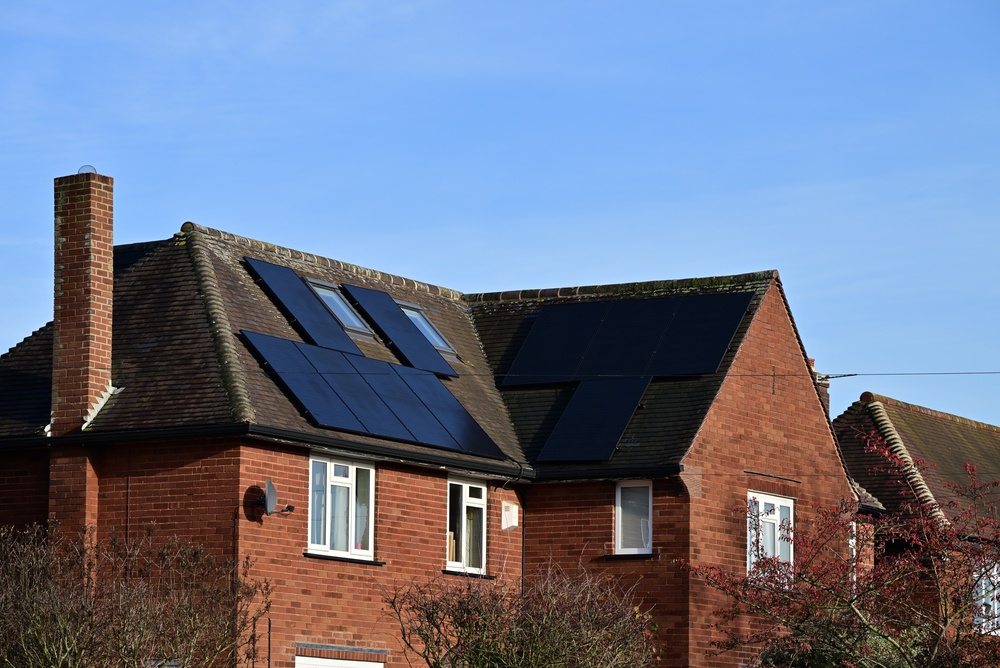 Red brick house roof with multiple residential solar panels in UK