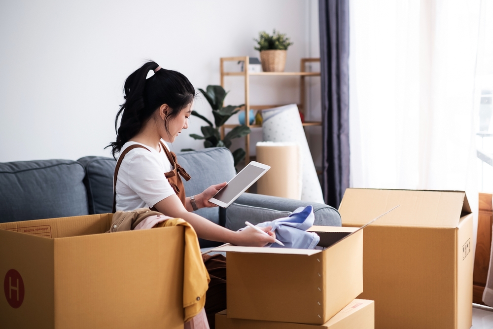 woman check list of stuff in the box while feeling proud and excited about buying a house with a mortgage loan