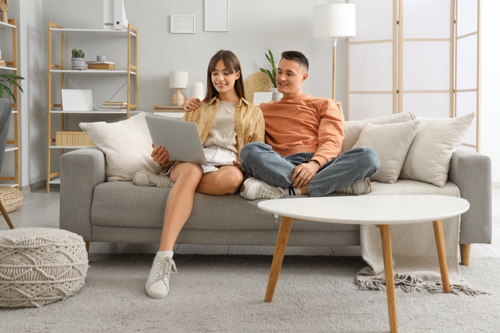 young couple on sofa using laptop