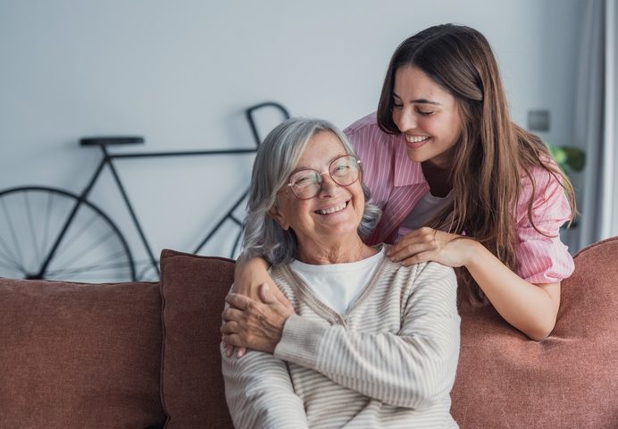 A young woman embraces her mature mother or grandmother at home