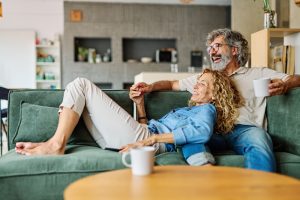 Couple sharing laughter on sofa inside during a quiet afternoon
