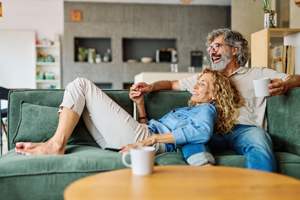 Couple sharing laughter on sofa inside during a quiet afternoon