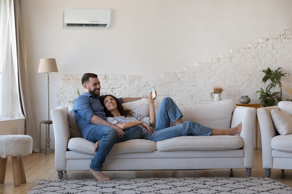 Happy couple smiling while laying on sofa