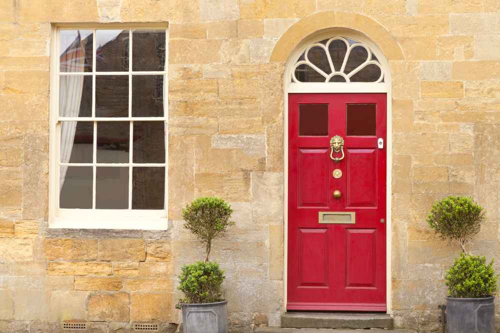 Red front doors of a traditional English stone cottage*